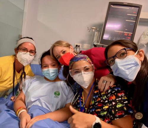 A team of volunteers and a child pose in a hospital