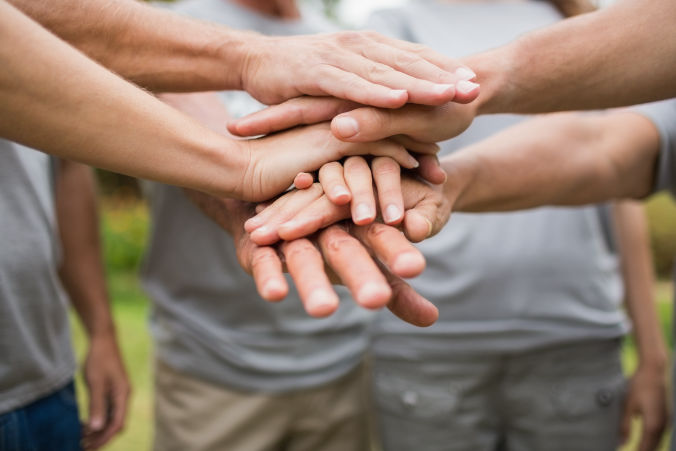 a team putting all of their hands in